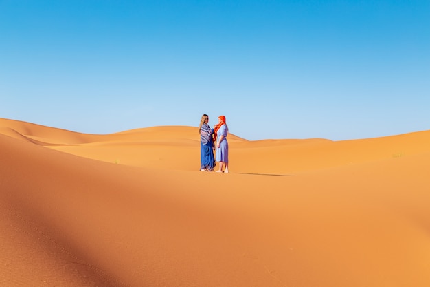 Due ragazze in velo nel deserto del sahara.