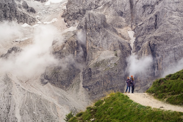 イタリア、ドロミテの山に立っているバックパックを持つ2人の女の子のハイカー