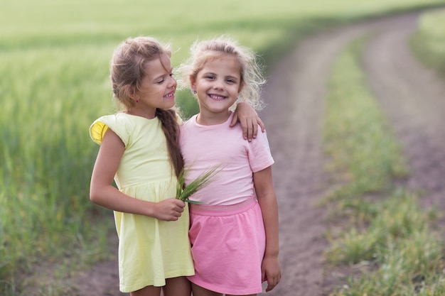 2人の女の子がフィールドで抱擁し、1人が他を見る