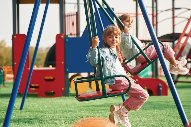 写真 2人の女の子子供たちが遊び場で楽しんでいます