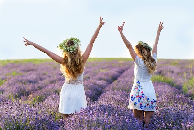 Two girls in a lavender field. Happy women Having fun. Friendship Day Portrait