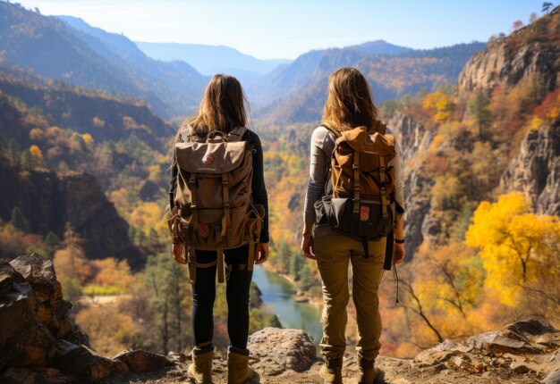 写真 2人の女の子が谷から目をそらしバックパックを背負った2人の女性が谷を眺めています