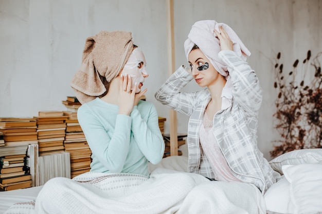 Two girls make masks and patches for the beauty of face and hair