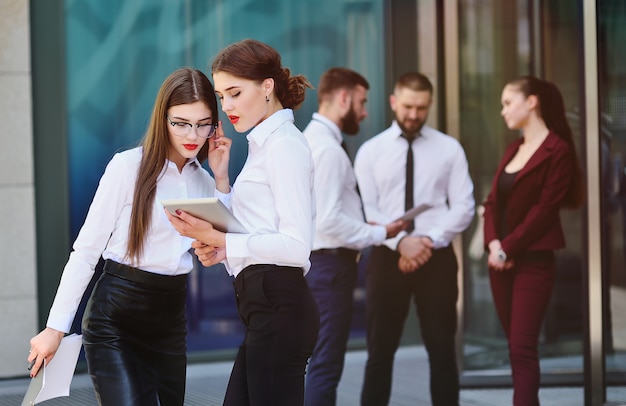 Two girls in office style clothes on building