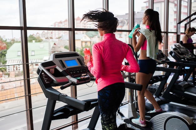 Two girls running on the treadmill