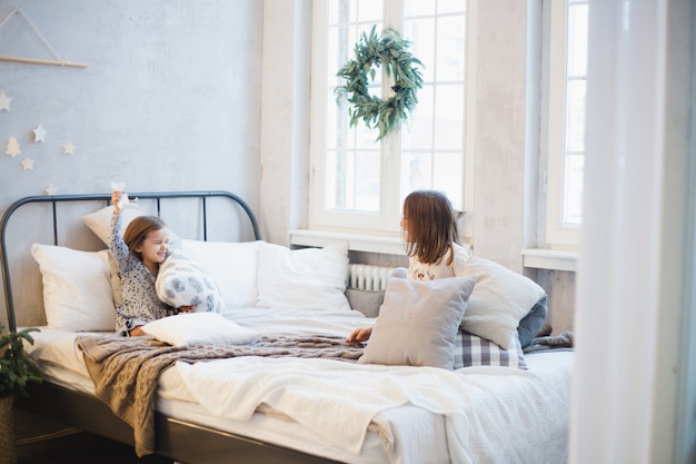 Two girls sisters fight pillows