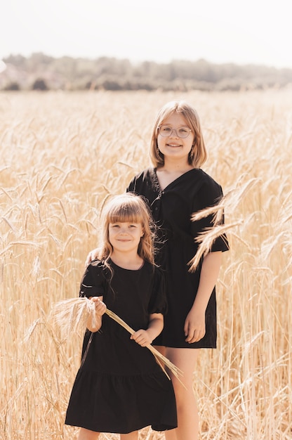 Two girls sisters hugging in nature in the summer