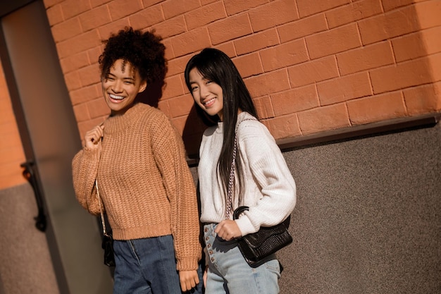 Due ragazze. ragazze sorridenti in piedi al muro