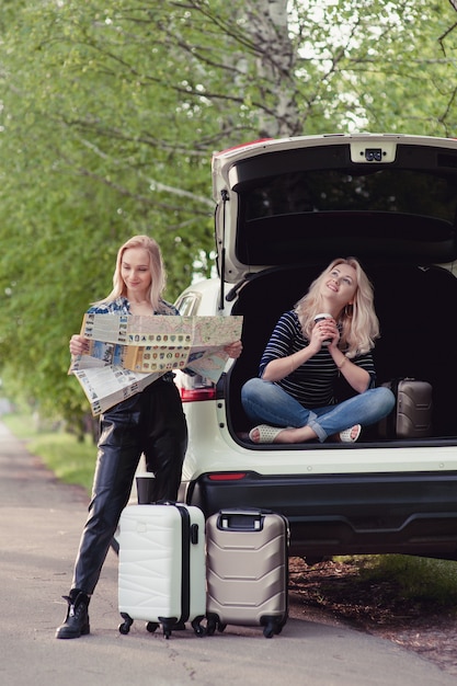 Two girls stopped on the road to get directions and drink coffee