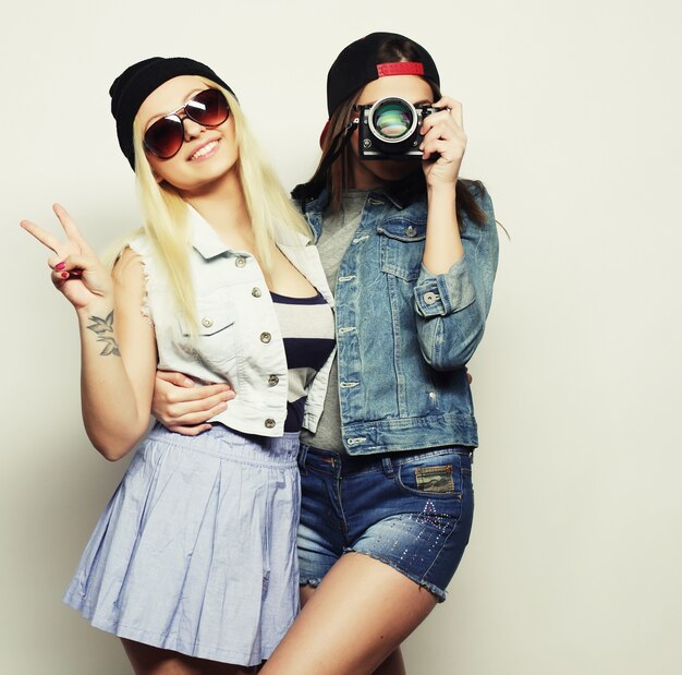 Two girls with cameras in hipster style over grey background