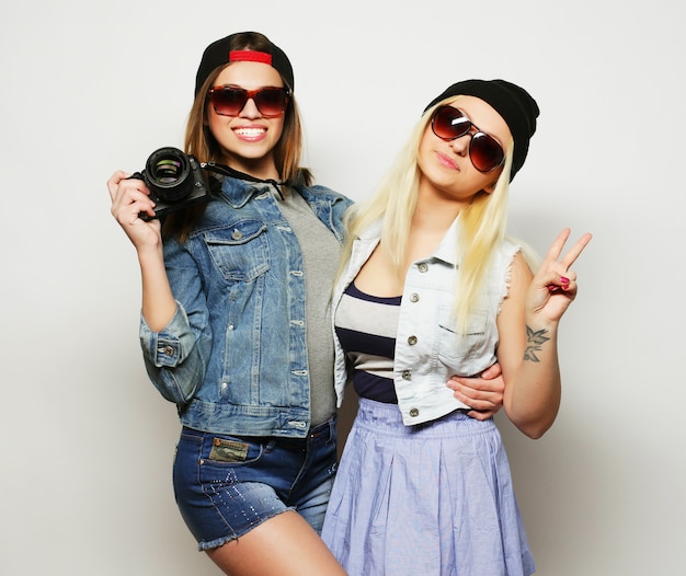 Two girls with cameras in hipster style over grey