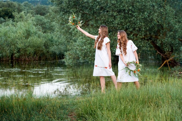 写真 手に花の花輪を持つ2人の女の子