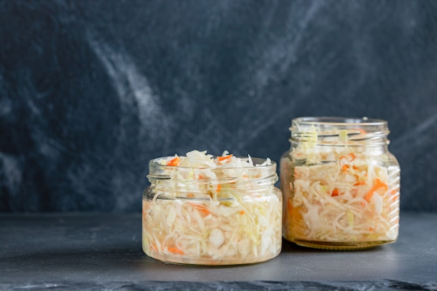 Two glass jars with sauerkraut are standing 