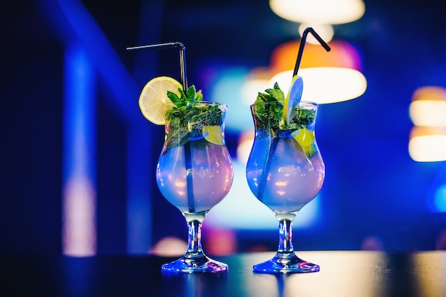 Two glass of Mojito cocktail with straws lime and mint at the party