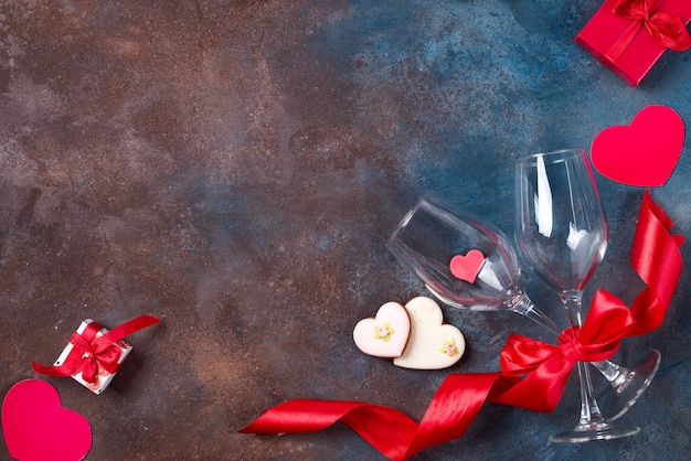 Two glass of wine, cookies hearts  on stone background. Valentine's Day 