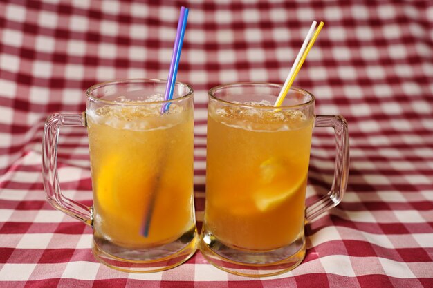 Two glasses of beer cocktails on plaid cloth