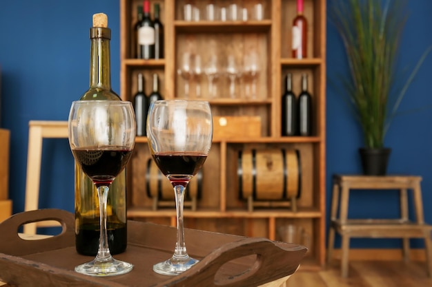 屋内の木製トレイに 2 つのグラスとワインのボトル