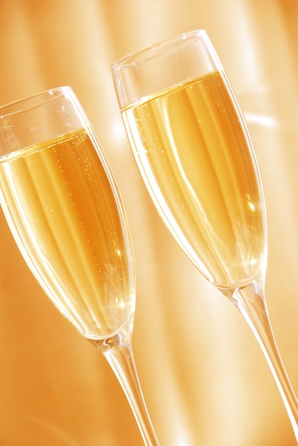 Two glasses of champagne against golden background