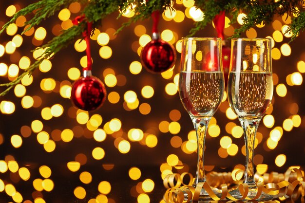 Two glasses of Champagne against shiny bokeh lights background