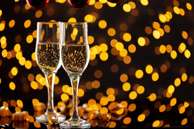 Two glasses of Champagne against shiny bokeh lights