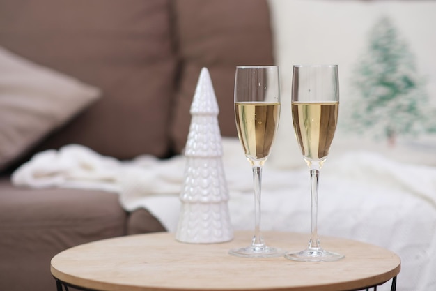 Two glasses of champagne on caffee table in living room christmas home interior ceramic christmas
