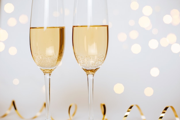 Two glasses of champagne with lights and ribbons