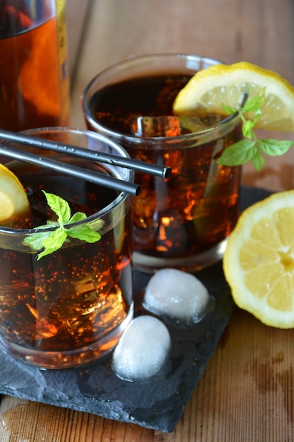 Two glasses of Cuba Libre cocktail with lemon and mint