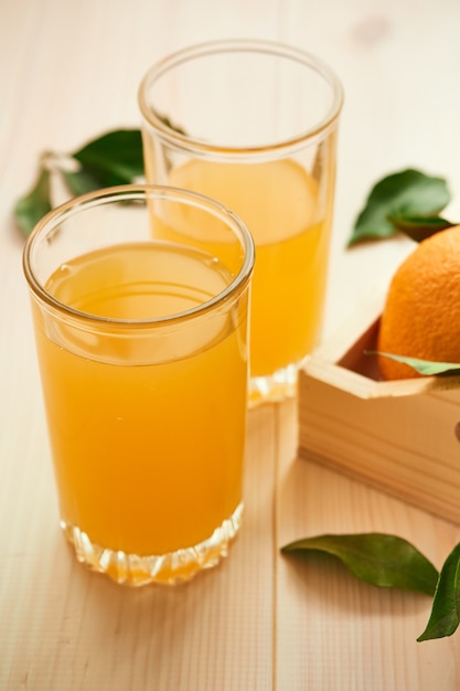 Two glasses of fresh orange juice on a wooden surface