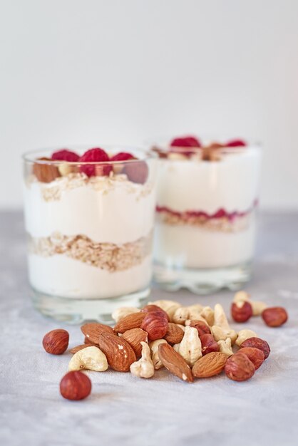 Two glasses of greek yogurt granola with raspberries