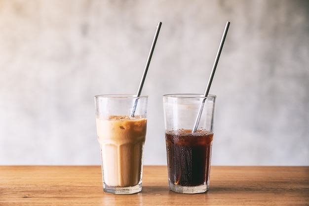 Two glasses of iced coffee with stainless steel drinking straw on wooden table