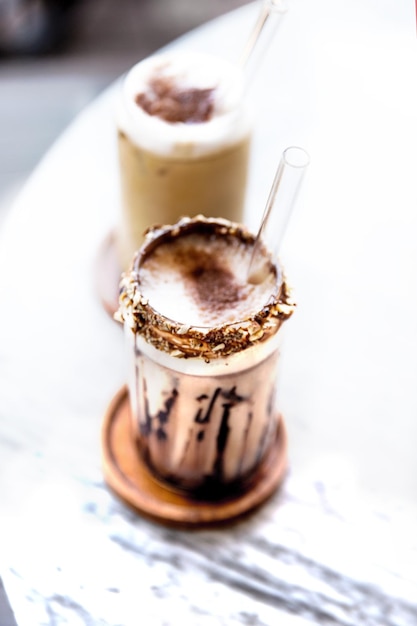 Two glasses of iced latte on marble background