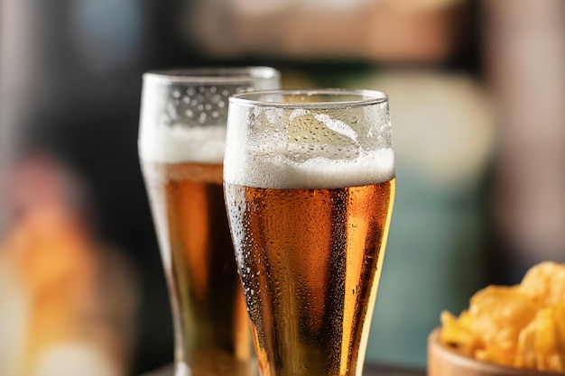 Two glasses of light foamy beer with drops on the side in bar
close up alcohol entertainment traditional drinks oktoberfest
atmosphere concept text space