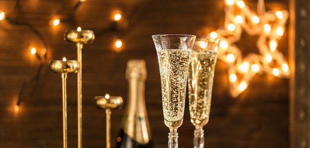 Два бокала шампанского на фоне праздничных огней. символ празднования нового года или рождества. новогодний праздник фон с золотым шампанским