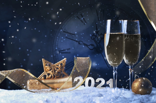 Два бокала шампанского с золотой лентой, звездой и шаром со снегом