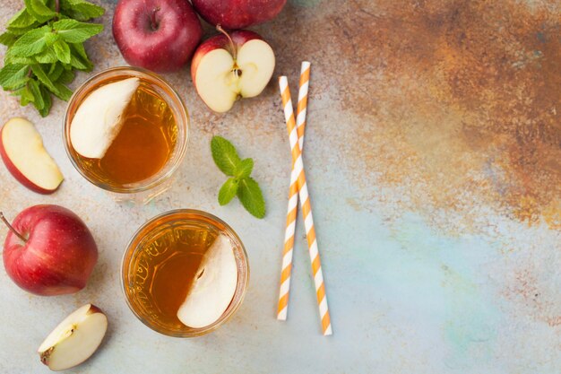 Фото Два стакана красного яблочного сока с мятой и льдом на старом ржавом столе.
