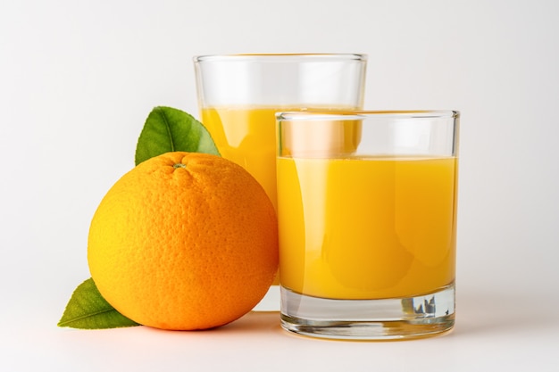 Two glasses of orange juice on white.