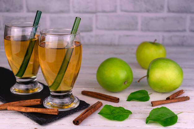 Two glasses of organic apple juice and green apples