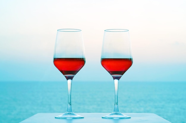 Two glasses of red wine on the background of the sea