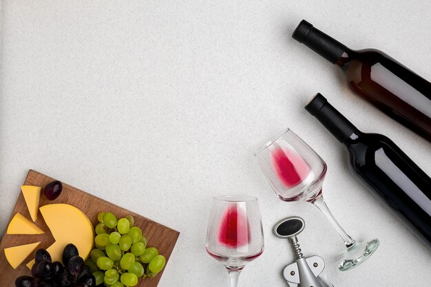 Два стакана красного вина, сыра и винограда, вид сверху