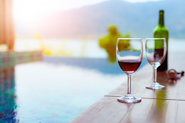 Two glasses of red wine near the swimming pool with a spectacular view of the sea