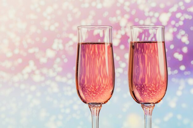 Two glasses of rose champagne with a light snow bokeh