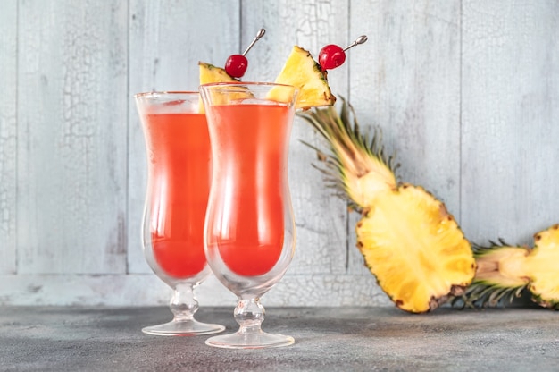 Two glasses of Singapore Sling on wooden wall