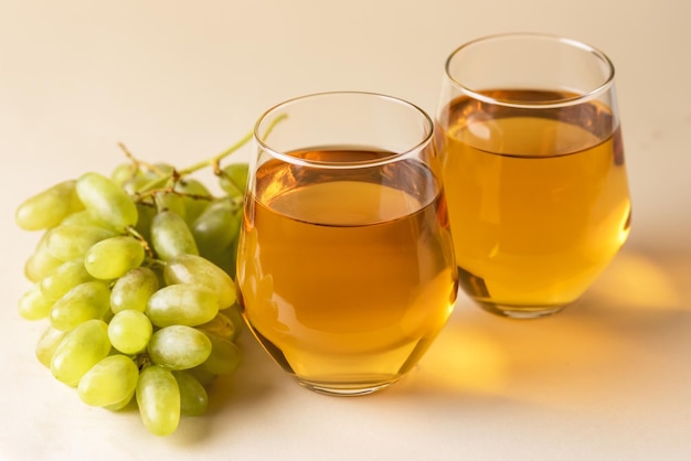 Two Glasses of Tasty Grape Juice on Yellow Background Healthy Drink Raw Green Grape Horizontal