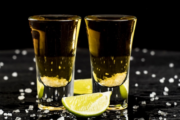 Photo two glasses of tequila with lime and salt