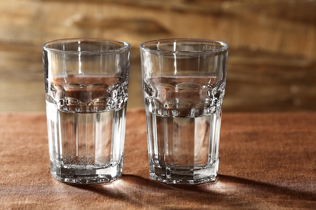 Два стакана воды на столе на деревянном фоне