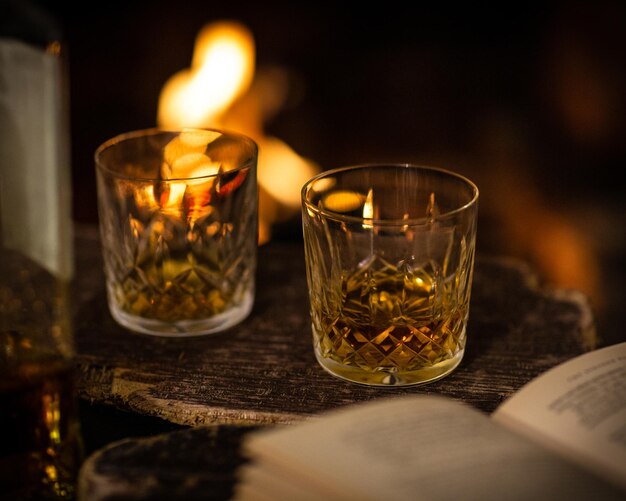 Two glasses of whiskey in front of the fireplace