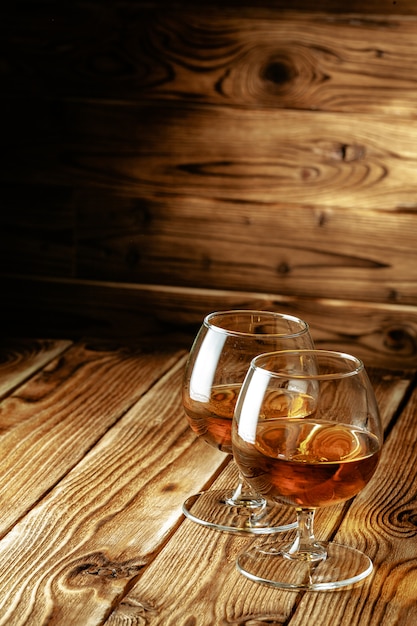 Photo two glasses of whiskey on a wooden table in the bar