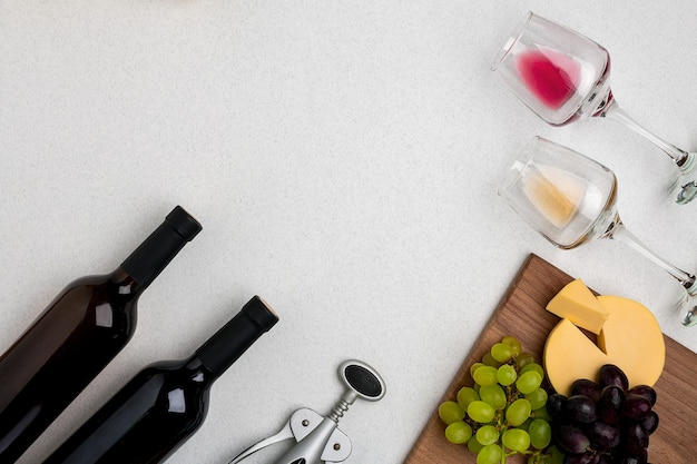 Due bicchieri di vino bianco e rosso, formaggio e uva vista dall'alto