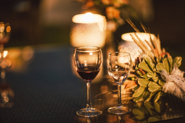 two glasses of wine on table on the background of wedding bouquet, evening, end of event