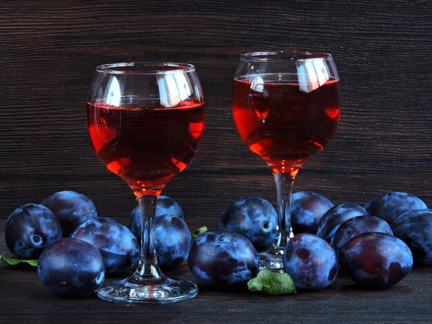 Two glasses of wine in a wine cellar. Bright blue plums